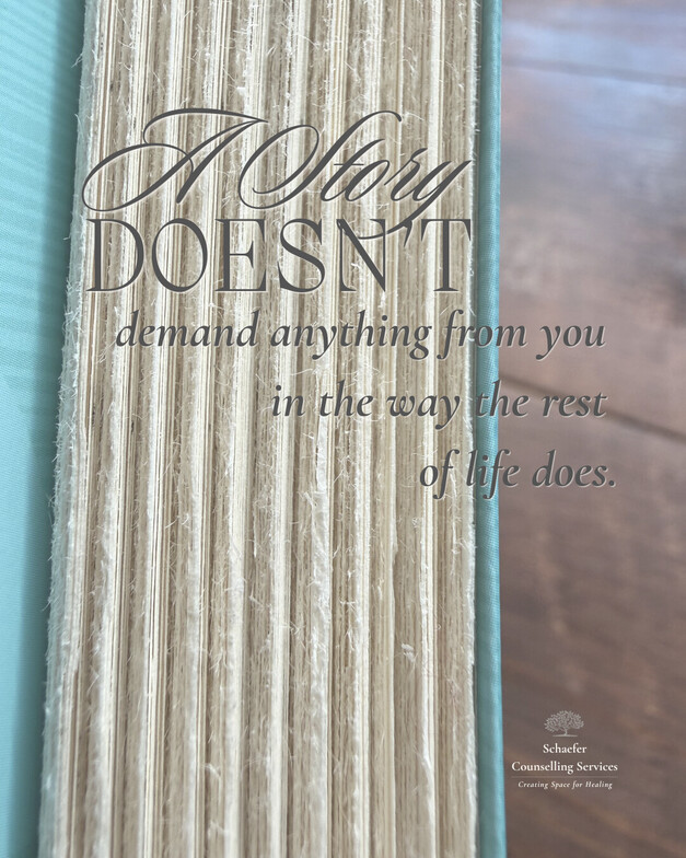 Close-up vertical shot of the textured edges of a closed book resting on a dark wood desk. Natural light highlights the paper. Text: "A story DOESN'T demand anything from you in the way the rest of life often does."