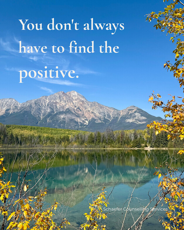 Pyramid Mountain reflected in lake with autumn leaves framing the image. Text reads, “You don't always have to find the positive.”
